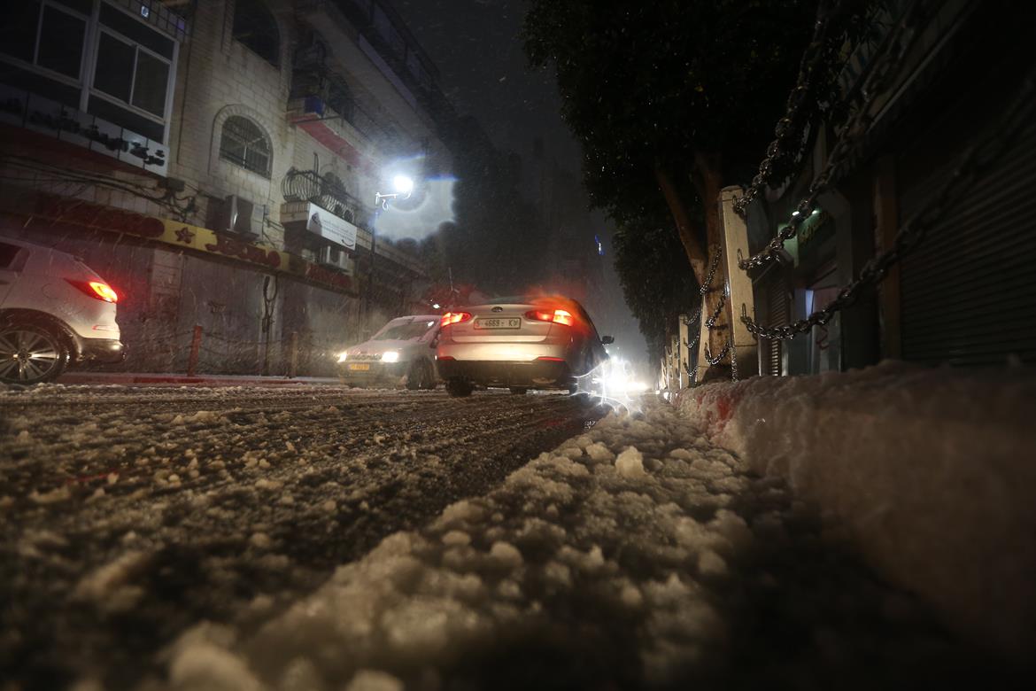 مركبات تسير وسط مدينة رام الله خلال المنخفض الجوي (عدسة: محمد أبو زيد/وفا)