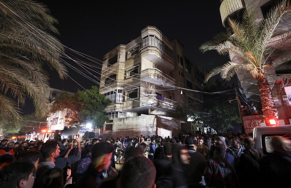 مواطنون يتجمعون أمام المبنى السكني الذي اندلع فيه الحريق-(تصوير: أ ف ب)