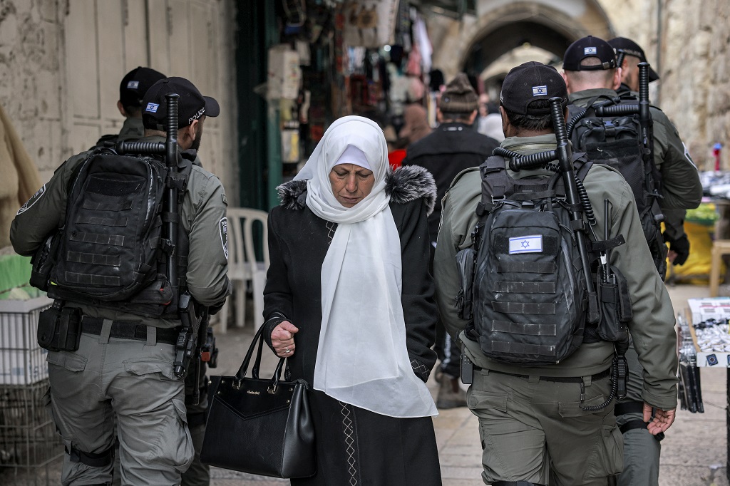 صورة توضيحية- مواطنة تمر من وسط عناصر لقوات الاحتلال الإسرائيلي في البلدة القديمة من مدينة القدس المحتلة (أرشيف: أ ف ب)