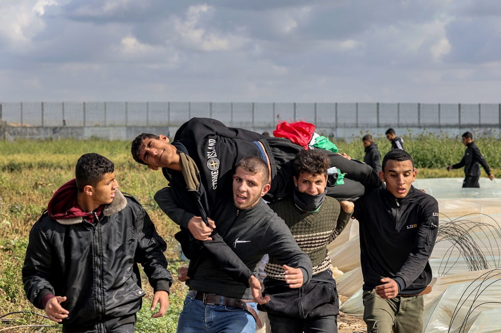 شبان ينقلون أحد المصابين (تصوير: أ ف ب)