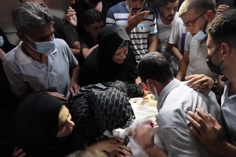 ذوو الشهيد أحمد صالح يلقون نظرة الوداع الأخيرة على جثمانه في منزل عائلته وسط بلدة جباليا