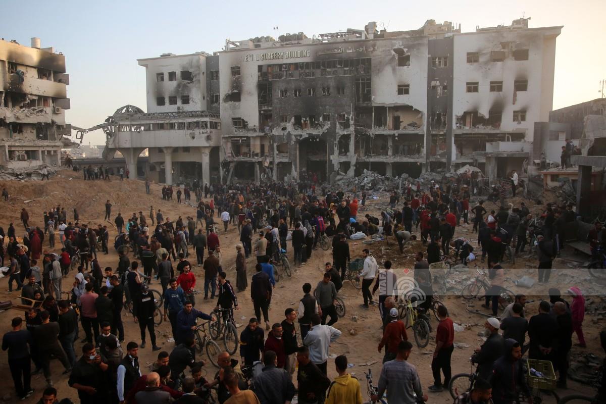 مواطنون يتفقدون الأضرار خارج مستشفى الشفاء بعد انسحاب جيش الاحتلال الإسرائيلي من المجمع ومحيطه (AFP)
